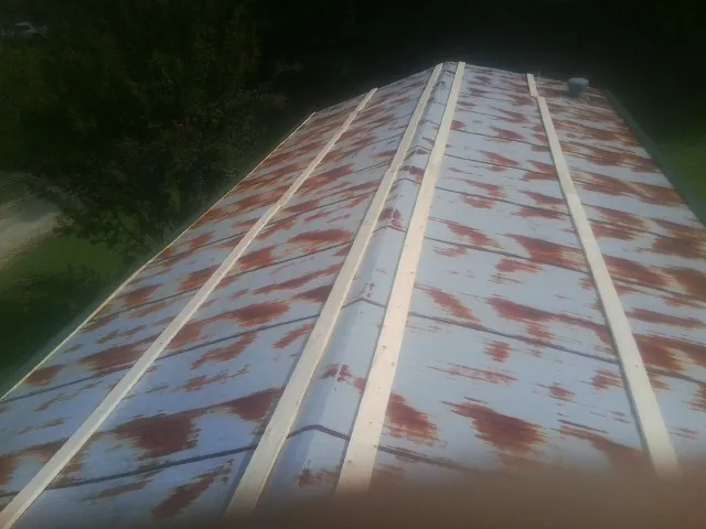 Rusted metal roof panels with new wood purlins before replacement — Storm Damage Roof Repair in Villard by Roofing Brothers