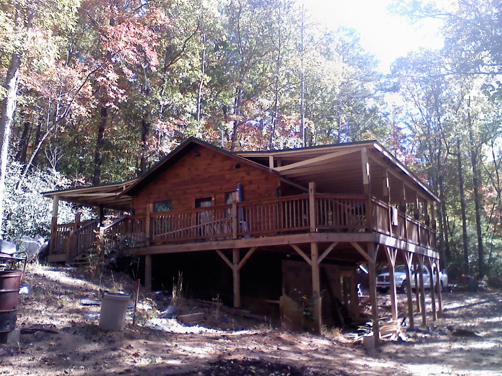 Log cabin with a wraparound porch and metal roof in the fall in Villard