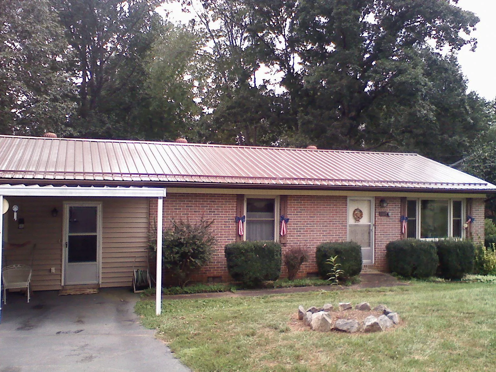 Bronze metal roof and carport on a brick ranch home — Roof Repair work by our crew in Villard